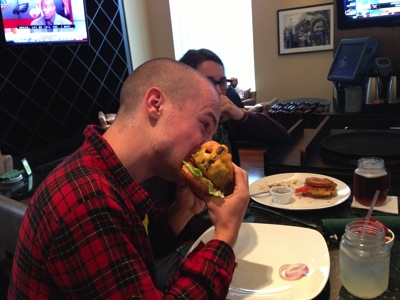 A picture of Eli eating a ridiculous burger