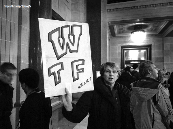A protestor holding up a banner that reads 'WTF Walker?'