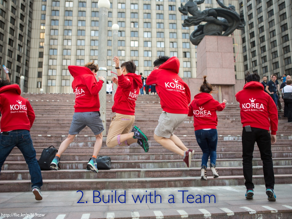 A group of teenagers in red sweatshirts jumping in the air in sync. The caption reads '2. Build with a Team.'
