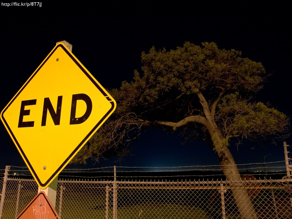 A photograph of a construction sign that reads 'END' against a nighttime backdrop.